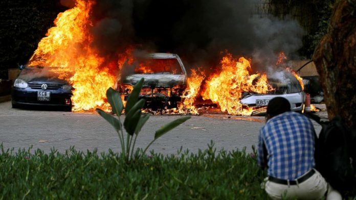 (Thomas Mukoya/Reuters) Cars are seen on fire at the scene of explosions and gunshots in Nairobi, Kenya, Jan. 15, 2019.