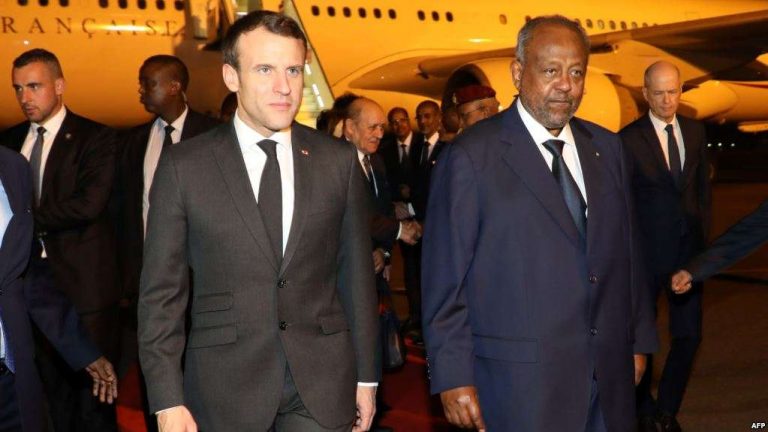 French president Emmanuel Macron (C) is welcomed by Djibouti's president Ismail Omar Guelleh upon his arrival at Djibouti's airport, March 11, 2019, in Djibouti, at the start of his trip to eastern Africa