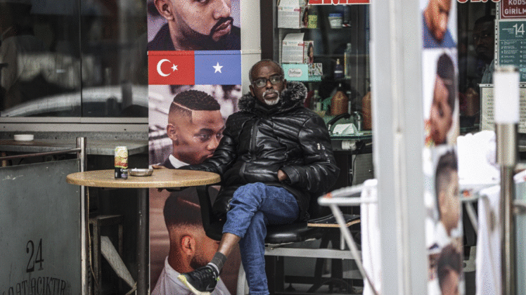 ANKARA, TURKEY - MARCH 31: A Somalian man sits outside a barber in Turkish capital Ankara on March 31, 2021. In recent years, many Somalian entrepreneurs who have turned the increase in the number of Somalis living in the capital Ankara into an opportunity and added value to the city with their restaurants, cafes, barbers, hairdressers and markets. Compared to other cities, Ankara's transportation network is well developed, for this reason as well as being the capital city Ankara is preferred by Somalians. Somalians call the city the Mogadishu of Turkey. ( Esra Hacioğlu - Anadolu Agency )