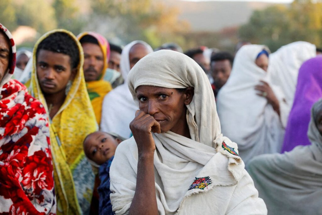 A woman stands in line to receive food donations, at the Tsehaye primary school, which was turned into a temporary shelter for people displaced by conflict, in the town of Shire, Tigray region, Ethiopia, March 15, 2021. REUTERS/Baz Ratner/File Photo