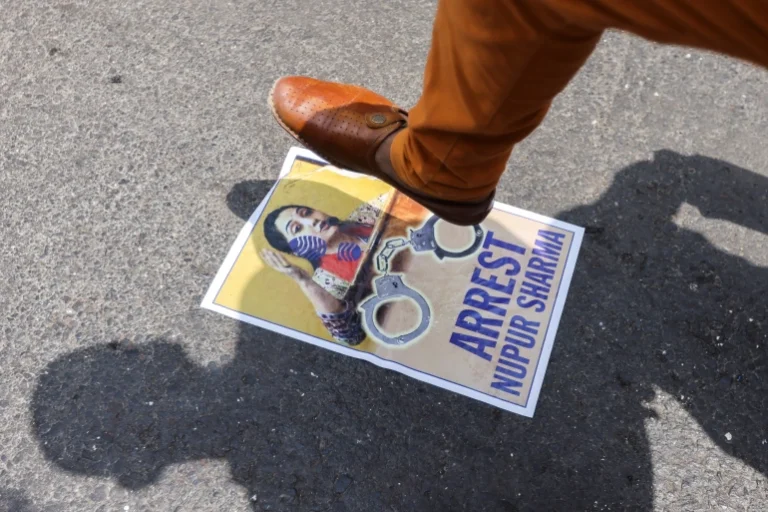 A demonstrator in Mumbai stomps a poster of BJP member Nupur Sharma during a protest after her comments on Prophet Muhammad [Francis Mascarenhas/Reuters]