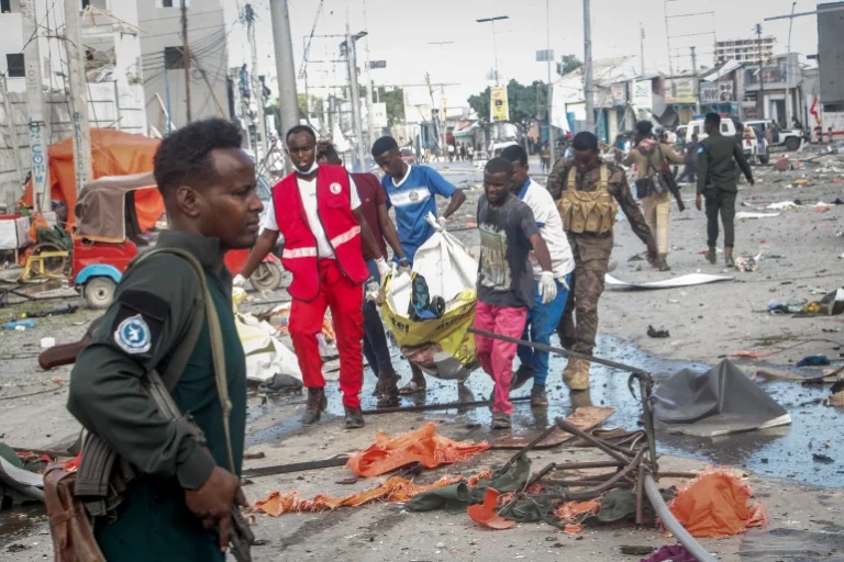 Rescuers remove a body from the scene of a double car bomb attack in Mogadishu, Somalia, on October 29, 2022 [Farah Abdi Warsameh/ AP]