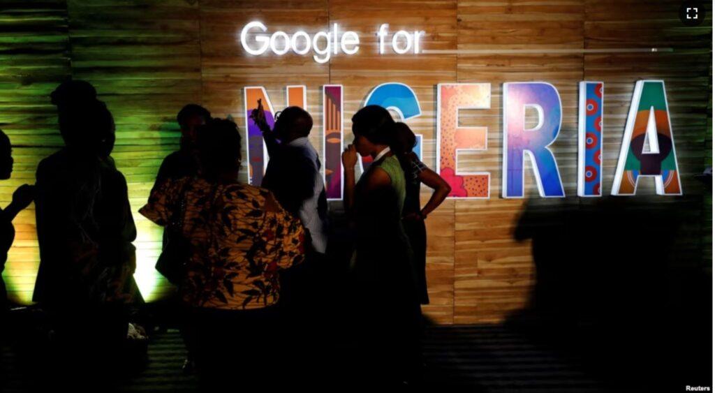 FILE — Participants walk past glowing signs during a conference tagged "Google for Nigeria" in Lagos, Nigeria, July 27, 2017.