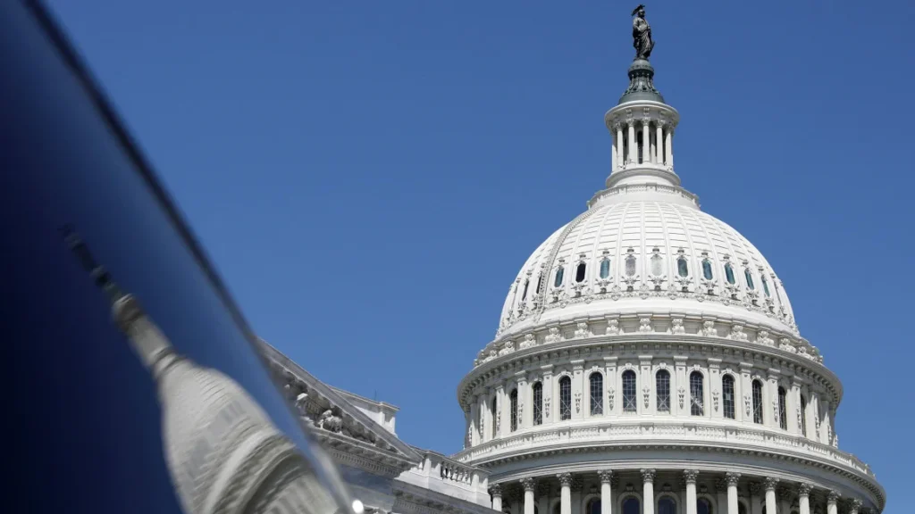 The dome of the US Capitol is reflected in a window on Capitol Hill in Washington, DC, in April. Amanda Andrade-Rhoades/Reuters