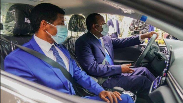 Ethiopian Prime Minister Abiy Ahmed (driving) and athletics legend Haile Gebrselassie test drive the first locally-assembled electric car in Addis Ababa on July 27, 2020. PHOTO | ETHIOPIAN EMBASSY