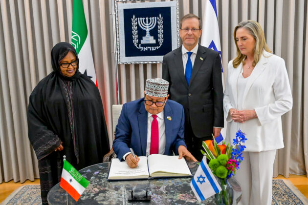 Somaliland President Abdirahman Mohamed Abdullahi Irro signs the official guest book at the Israeli President's Residence as Israeli President Isaac Herzog and First Lady Michal Herzog look on in Jerusalem, June 14, 2026. Photo courtesy: Israeli Presidency.